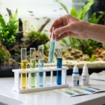Tubos de teste de água de aquário com cores diferentes ao lado da tabela de leitura